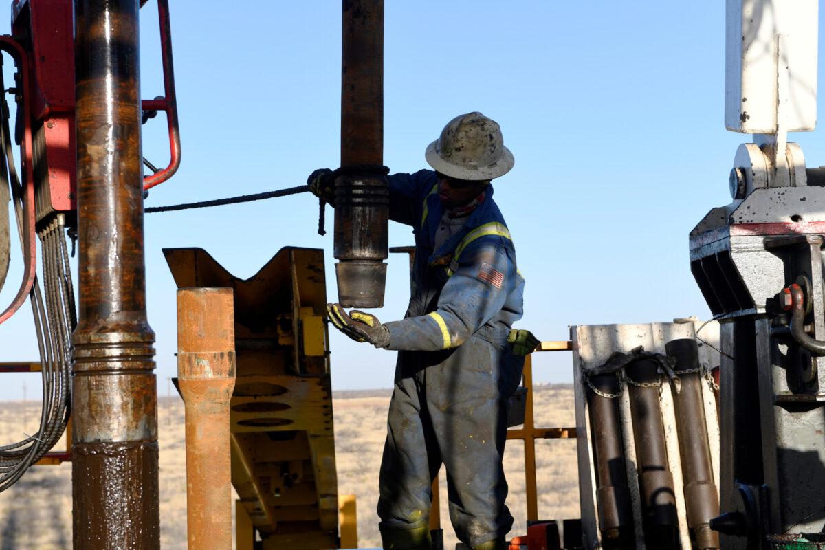 FILE PHOTO: An oil worker removes a thread cap from a piece of drill pipe on a drilling lease owned by Elevation Resources near Midland, Texas, U.S., Feb. 12, 2019. (Nick Oxford/File Photo/Reuters)