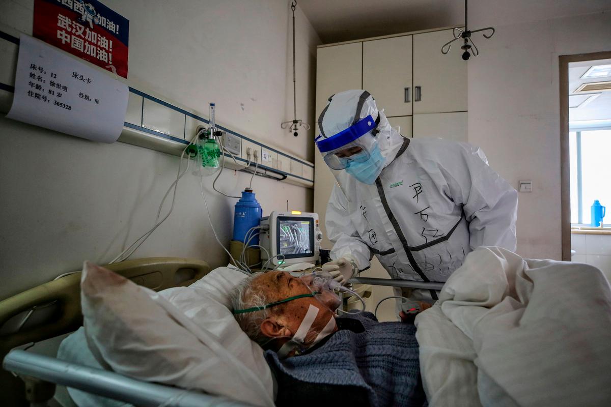 A medical staff member speaks with a patient infected by COVID-19 at Red Cross Hospital in Wuhan, China, on March 10, 2020. (STR/AFP via Getty Images)