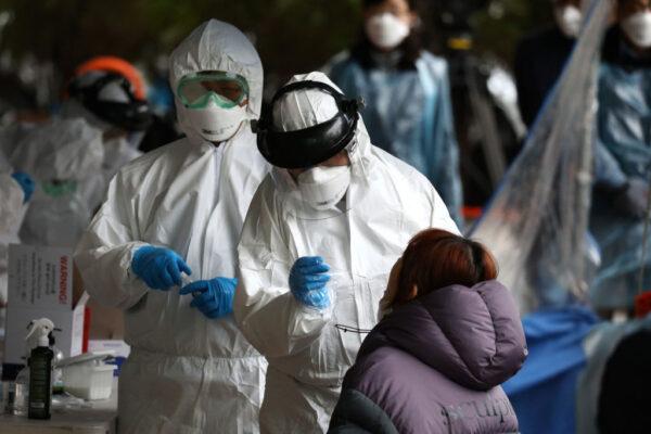 Medical staff, wearing protective gear, take samples from people at a building where 46 people were confirmed to have the novel coronavirus, at a temporary test facility in Seoul on March 10, 2020. (Chung Sung-Jun/Getty Images)