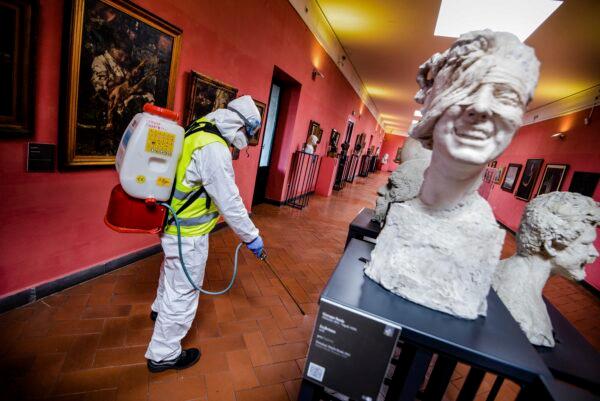 A worker sprays disinfectant as sanitization operations against Coronavirus are carried out in the museum hosted by the Maschio Angioino medieval castle, in Naples, Italy on March 10, 2020. (Alessandro Pone/LaPresse via AP)