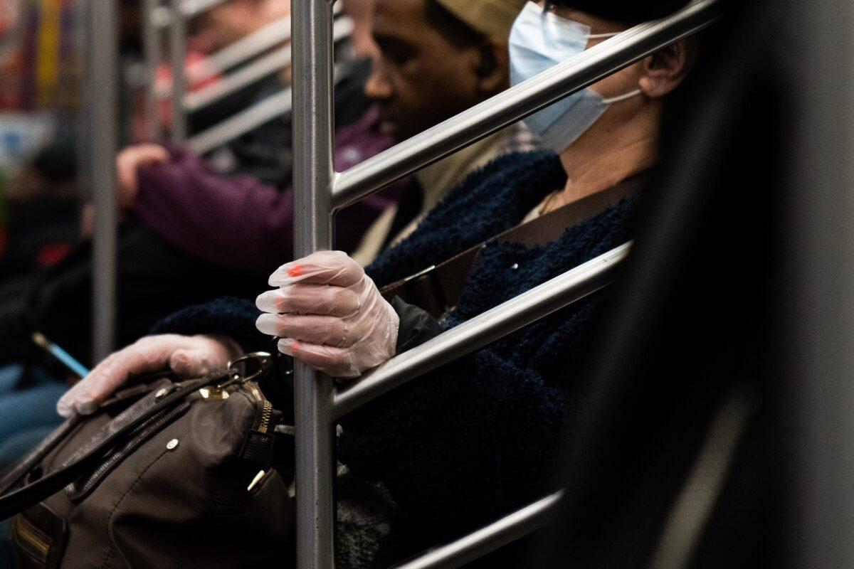 A woman wearing a protective mask rides a subway in New York City on March 9, 2020. (Jeenah Moon/Getty Images)