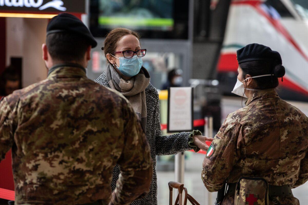 Italian soldiers speak to a passenger at Milano Centrale train station in Milan, Italy, on March 10, 2020. (Emanuele Cremaschi/Getty Images)
