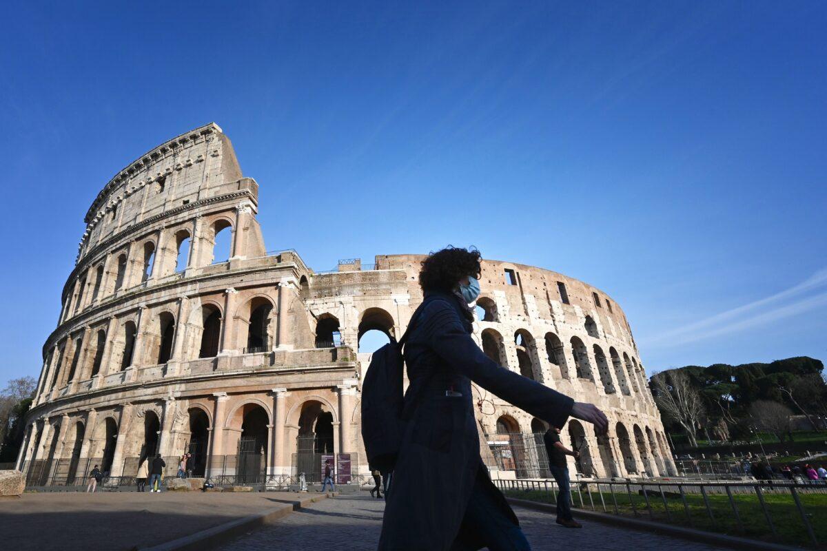 A tourist wearing a respiratory mask as part of precautionary measures against the spread of the COVID-19 coronavirus, walks past the closed Colosseum monument in Rome, Italy, on March 10, 2020. (Alberto Pizzoli/AFP via Getty Images)