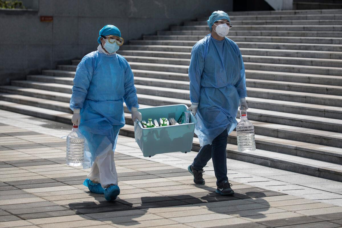 Medical workers carry a box in Wuhan, Hubei Province, China, on March 10, 2020. (Stringer/Getty Images)