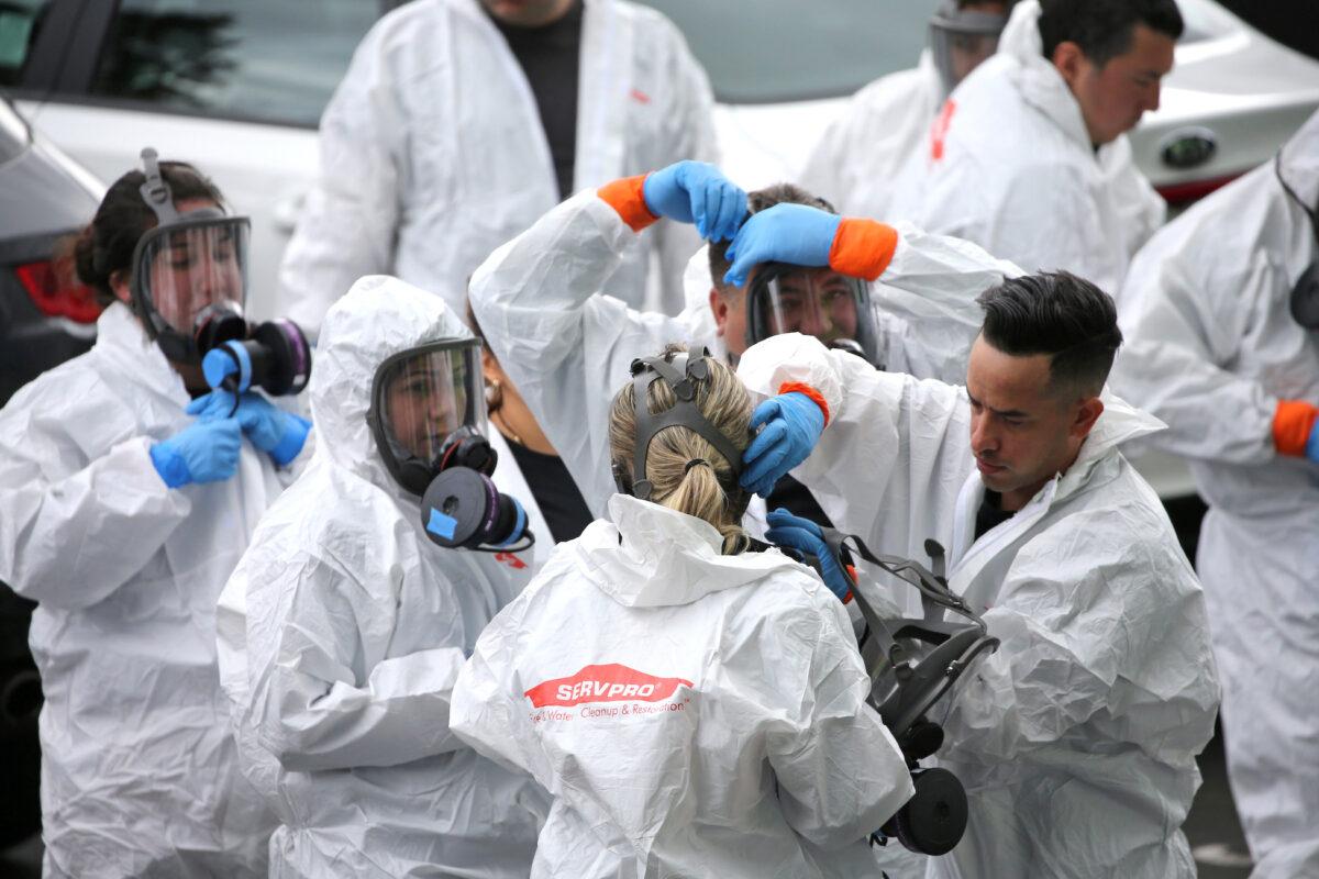 Clean up crews from Servpro gear up to go inside the Life Care Center of Kirkland, the long-term care facility linked to several confirmed coronavirus cases in Washington state on March 11, 2020. (Karen Ducey/Reuters)