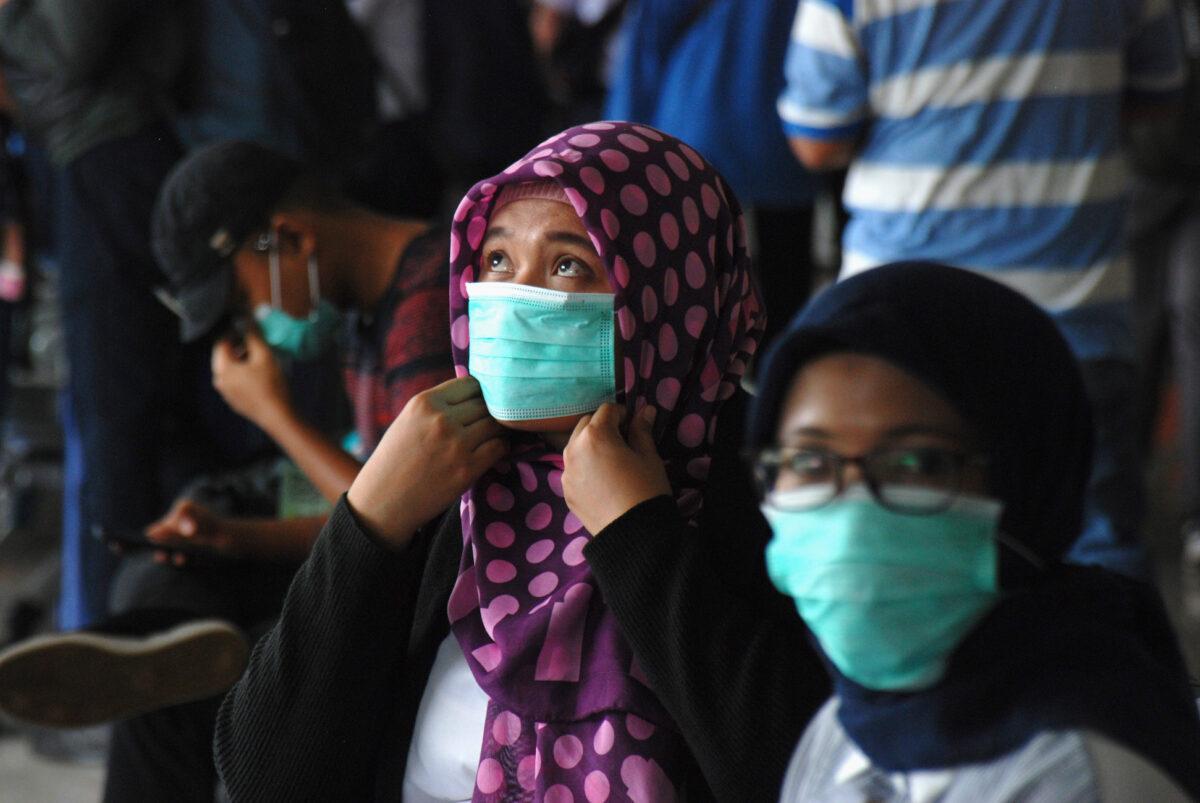 People wearing face masks wait at a train station in Bandung, in Indonesia's West Java on March 5, 2020. (Timur Matahari/AFP via Getty Images)