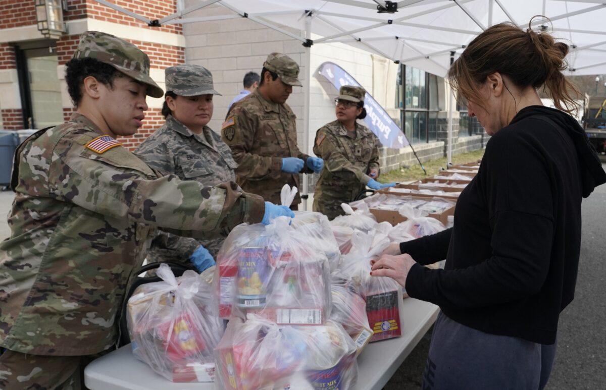National Guard troops give food to residents of New Rochelle, New York at New Rochelle High School on March 12, 2020. (Timothy A. Clary/AFP via Getty Images)