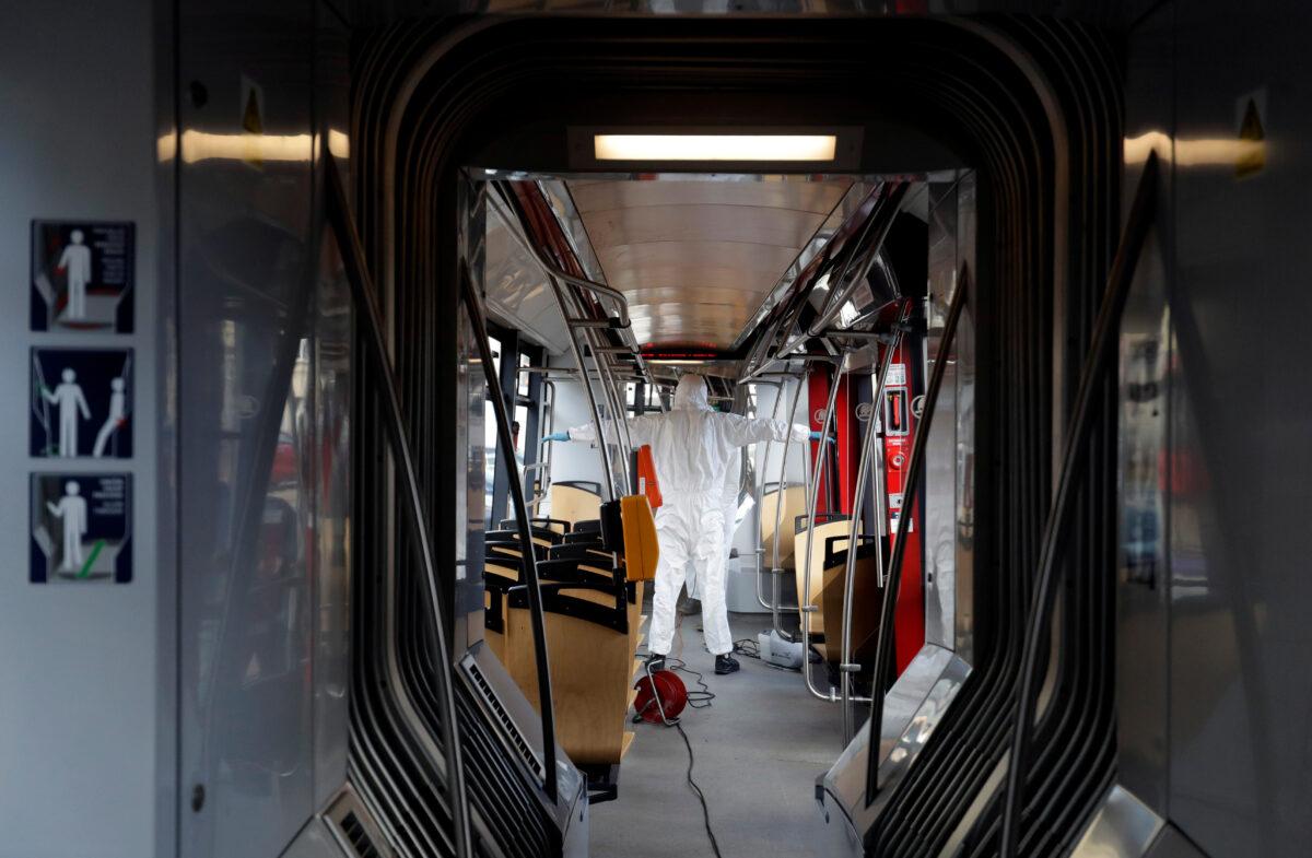 Workers in protective suits prepare to disinfect a tram due to coronavirus disease (COVID-19) concerns in Prague, Czech Republic, March 12, 2020. (David W Cerny/Reuters)
