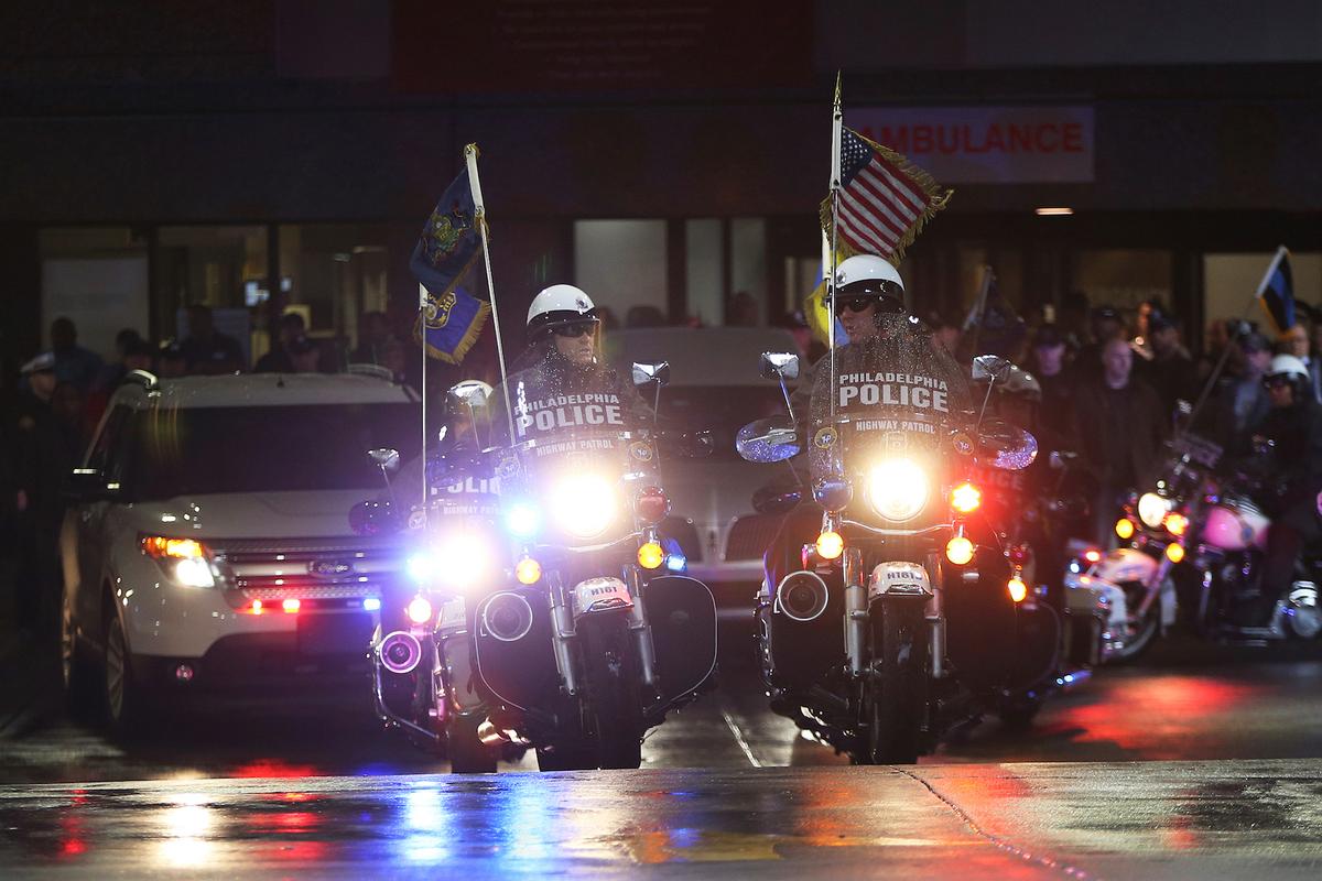 Philadelphia police highway patrol officers lead the procession after the body of SWAT Cpl. James O’Connor was brought to a hearse at the emergency room entrance at Temple University Hospital in North Philadelphia on March 13, 2020.