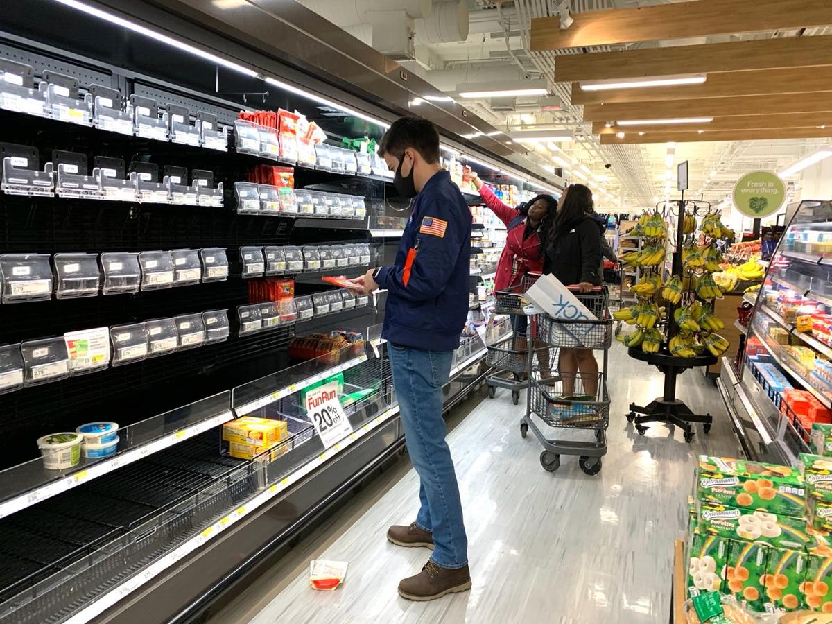 A man stands in front of almost empty shelves in the dairy goods section at a Target store in Manhattan, New York, on March 13, 2020. (Chung I Ho/The Epoch Times)