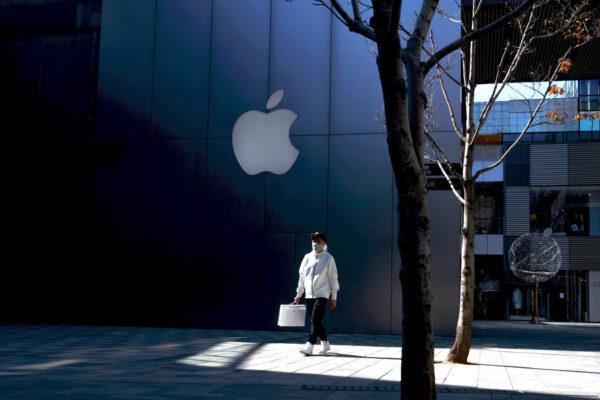A man wearing a face mask walks past an Apple store in an upmarket shopping district in Beijing as the country is hit by an outbreak of the novel coronavirus, on March 4, 2020. (Reuters/Thomas Peter)