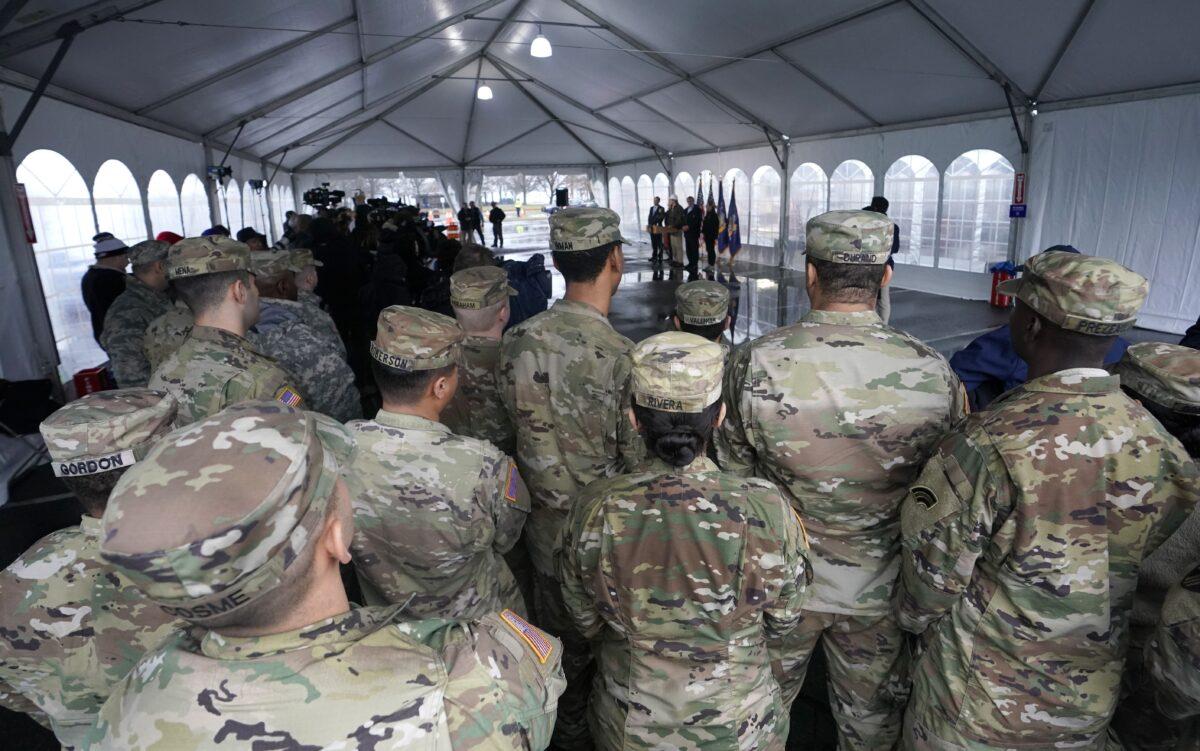 National Guard troops listen to New York Governor Andrew Cuomo as people wait to be tested for COVID-19 at the state's first drive-through coronavirus testing center at Glen Island Park in New Rochelle, New York, on March 13, 2020. (Timothy A. Clary/AFP via Getty Images)