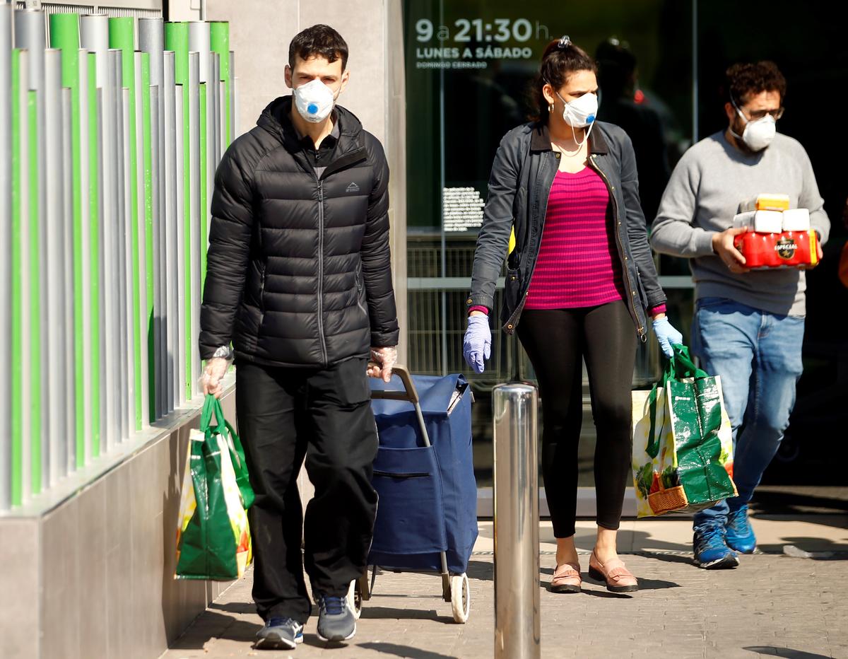People wearing masks walk out of a supermarket, amid concerns over Spain's coronavirus outbreak in central Madrid, Spain, on March 14, 2020. (Javier Barbancho/Reuters)