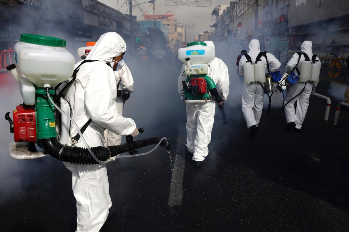 Firefighters disinfect a street against the new coronavirus in western Tehran, Iran, on March 13, 2020. (Vahid Salemi/AP Photo)