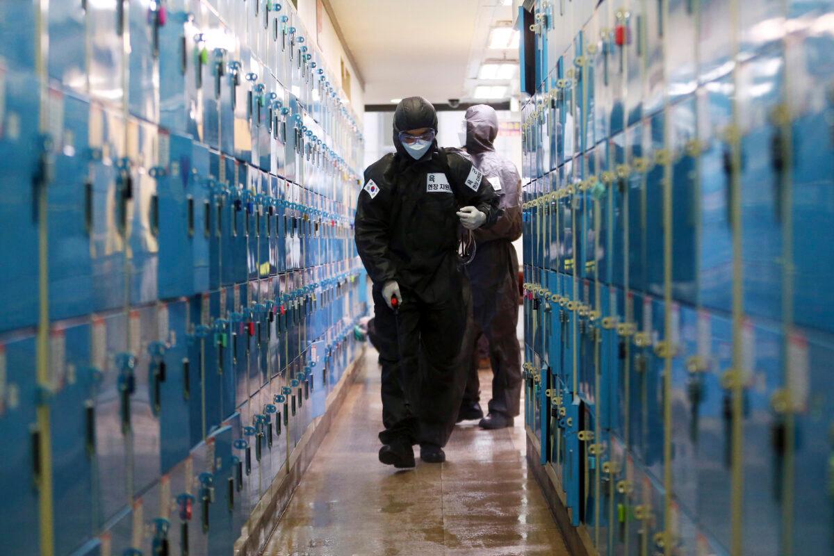 A South Korean army soldier wearing a protective suit sprays disinfectant as a precaution against the new coronavirus at a private academy in Daegu, South Korea, on March 15, 2020. (Kim Hyun-tae/Yonhap via AP)