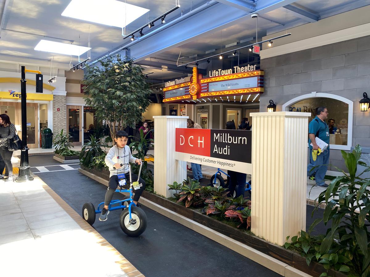 A special needs student rides a tricycle in LifeTown Shoppes, an indoor Main Street with businesses that allow for students with special needs to practice how to interact in real-world settings, in Livingston, N.J., on March 2, 2020. (REUTERS/Roselle Chen)