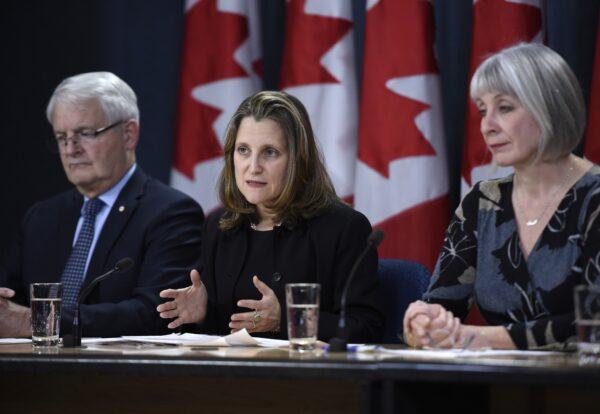 (L-R) Transport Minister Marc Garneau, Deputy Prime Minister Chrystia Freeland, and Health Minister Patty Hajdu participate in a press conference on COVID-19 at the National Press Theatre in Ottawa on March 16, 2020. (Justin Tang/The Canadian Press)