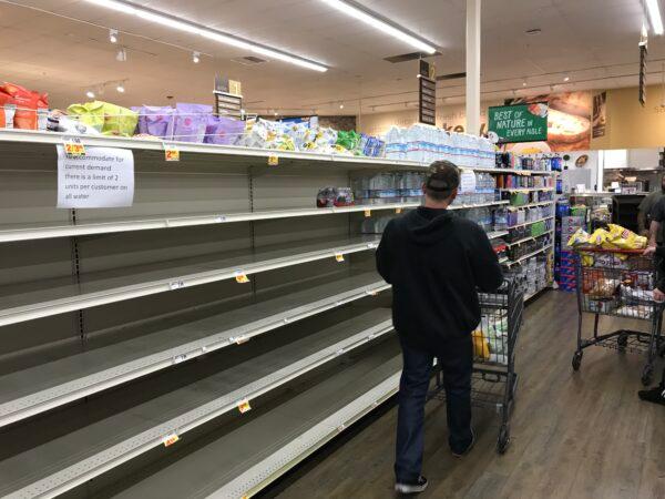 A customer shops the bottled water aisle in the Stater Bros. in Menifee, Calif., on March 15. 2020. (Brad Jones/The Epoch Times)