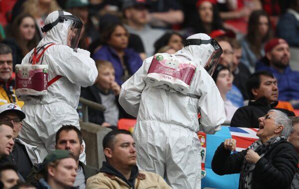 Fans dressed in HAZMAT suits with toilet paper "backpacks" referencing the shortages during the current COVID-19 crisis at BC Place in Vancouver, Canada, on March 08, 2020. (Trevor Hagan/Getty Images)