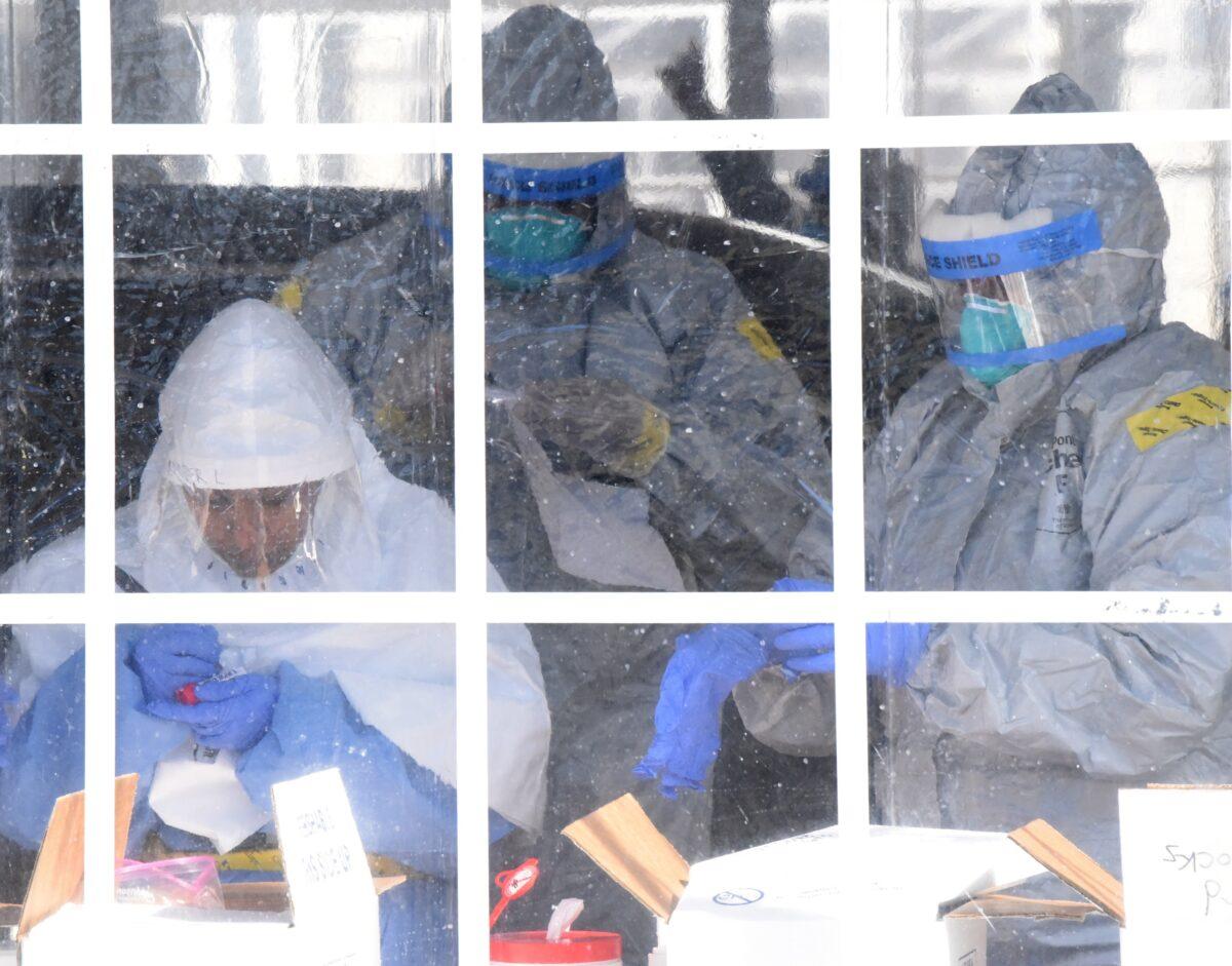 A medical professional, supported by New York Army National Guard members, collects swabs to test for coronavirus disease (COVID-19) infections in New Rochelle, New York, on March 15, 2020. (Senior Airman Sean Madden/U.S. Air National Guard/Handout via Reuters)