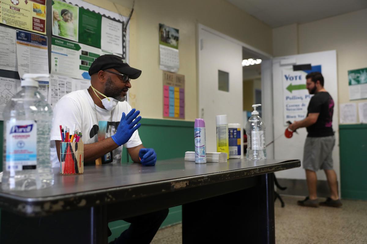 Voting precinct clerk Edgar Moore wears protective gloves and has a mask ready as people arrive to vote during the Florida presidential primary as the coronavirus pandemic continues in Miami, Florida, on March 17, 2020. (Joe Raedle/Getty Images)