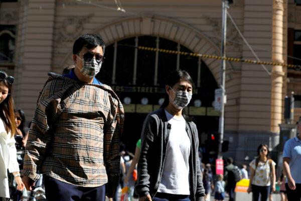 People wearing face masks walk by Flinders Street Station after cases of the coronavirus were confirmed in Melbourne, Victoria, Australia, on Jan. 29, 2020. (Reuters/Andrew Kelly)