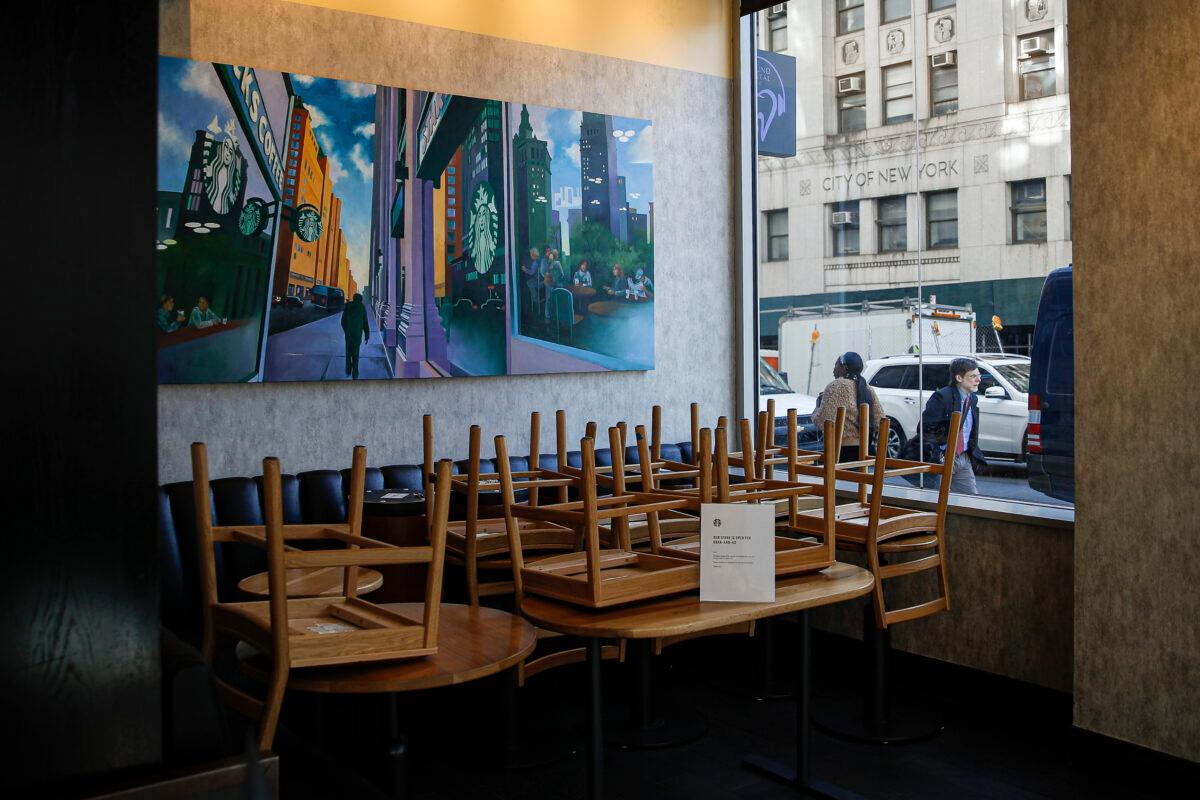 Chairs are stacked in a Starbucks coffee shop that remained open for customers purchasing for take-out in New York City on March 16, 2020. (John Minchillo/AP Photo)