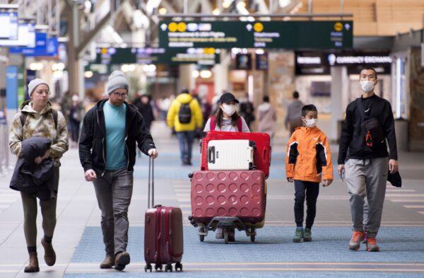 Travellers at Vancouver International Airport in Richmond, B.C., on March 13, 2020. The Canada Border Services Agency says it is adding new screening questions for travellers arriving in Canada, asking whether they have symptoms of COVID-19. (The Canadian Press/Jonathan Hayward)