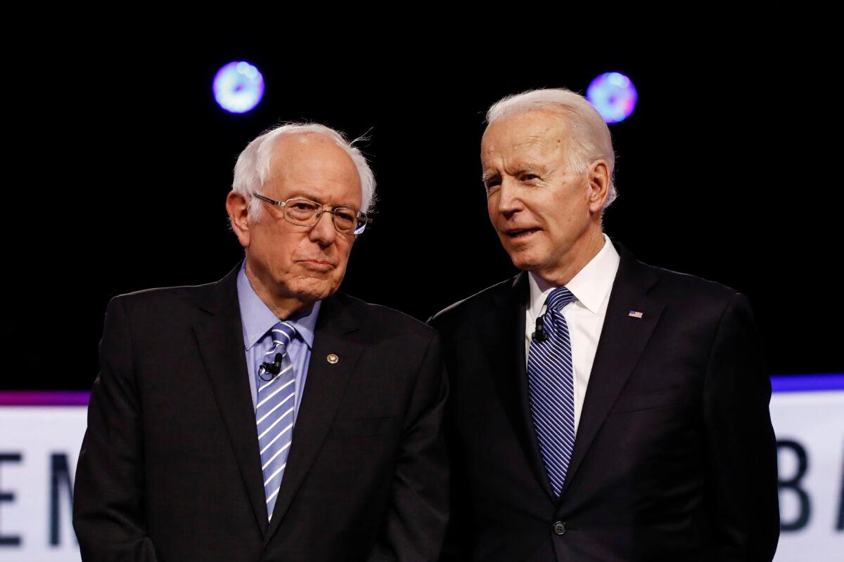 Then-Democratic presidential candidates Sen. Bernie Sanders (I-Vt.) (L) and former Vice President Joe Biden talk before a Democratic presidential primary debate in Charleston, S.C., on Feb. 25, 2020. (Matt Rourke/AP Photo)