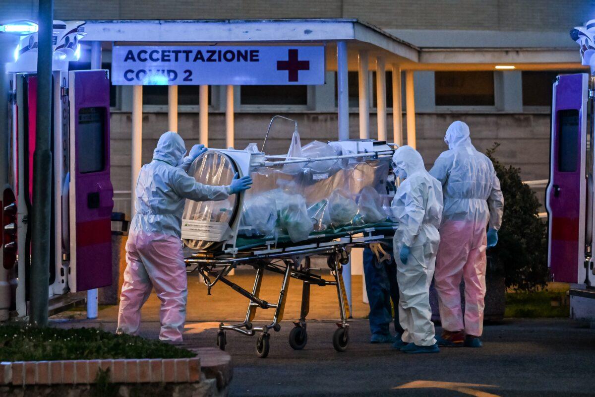 Medical workers in overalls stretch a patient under intensive care into the newly built Columbus Covid 2 temporary hospital at the Gemelli hospital in Rome on March 16, 2020. (Andreas Solaro/AFP via Getty Images)