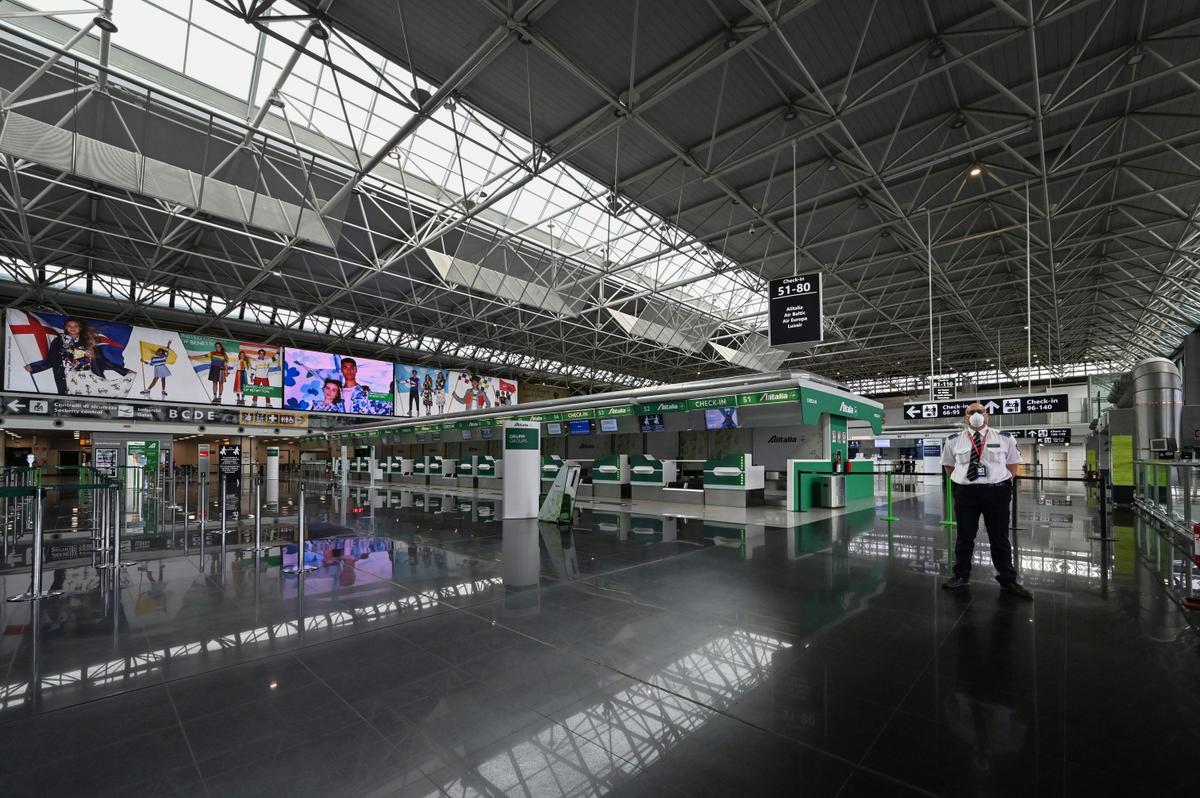 An airport security agent stands guard in the deserted Terminal T1 of Rome's Fiumicino International Airport on March 17, 2020. (©Getty Images | <a href="https://www.gettyimages.com/detail/news-photo/an-airport-security-agent-stands-guard-in-a-deserted-news-photo/1207457063?adppopup=true">ANDREAS SOLARO</a>)