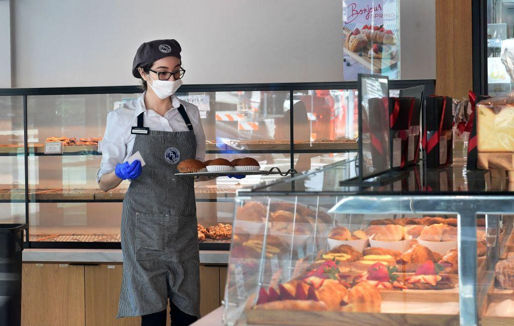 An employee at a cafe and bakery wears a facemask in Los Angeles, Calif., on March 17, 2020. (Frederic J. BROWN/AFP via Getty Images)
