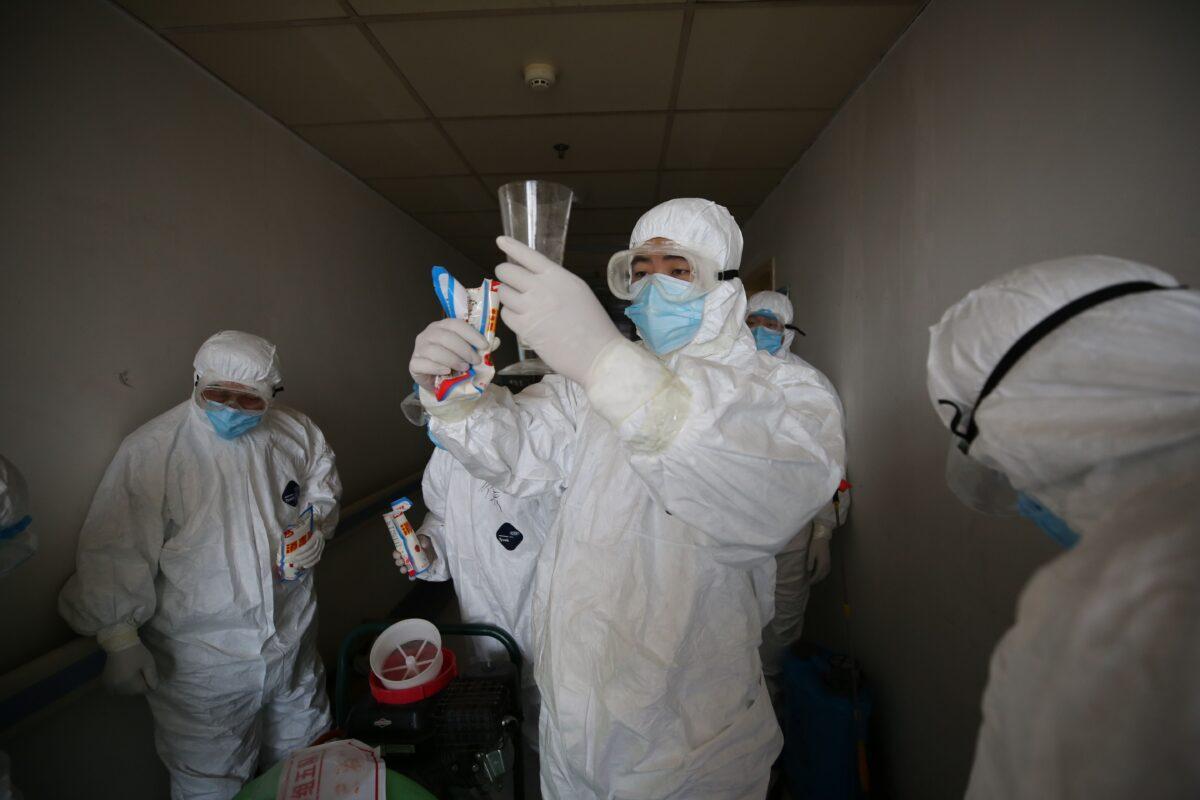 Workers prepare to disinfect rooms at the Red Cross hospital in Wuhan, China, on March 18, 2020. (STR/AFP via Getty Images)