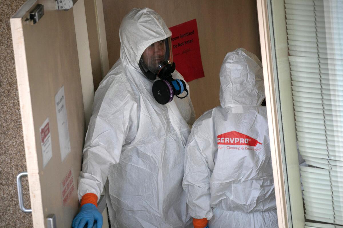A cleaning crew wearing protective clothing enters a long-term care facility where a COVID-19 outbreak occurred, on March 12, 2020, in Kirkland, Washington. (John Moore/Getty Images)
