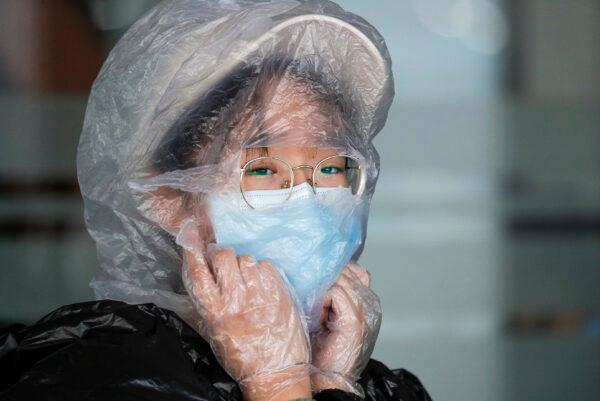A Chinese woman uses a plastic bag to cover her head while waiting for her flight at the departure area of Manila's International Airport, Philippines, on March 18, 2020. (Aaron Favila/AP Photo)