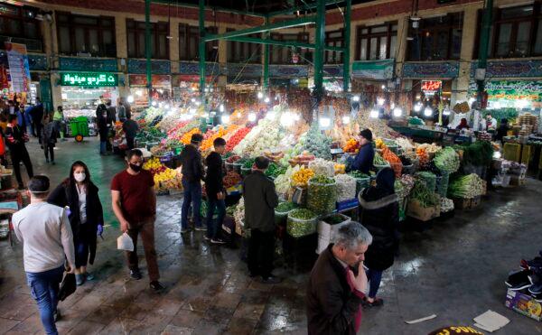 People, some wearing protective face masks, grocers stalls displaying produce at the Tajrish Bazaar in Iran's capital Tehran on March 12, 2020. (AFP via Getty Images)