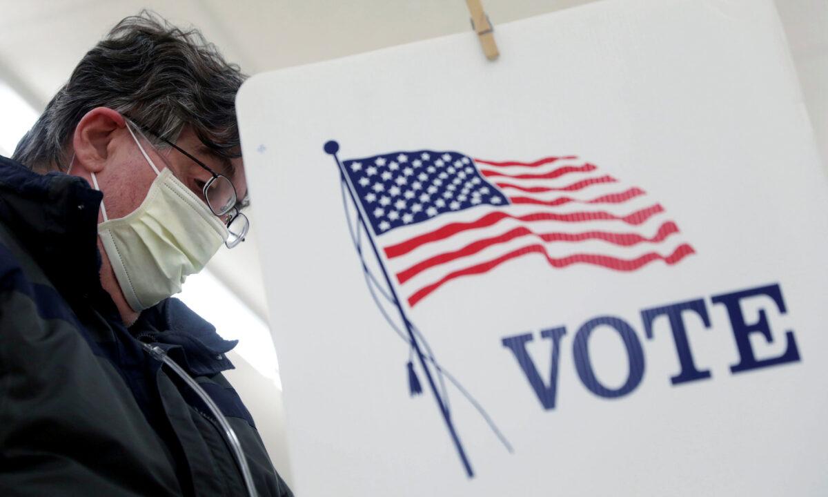 A voter fills out his ballot during the primary election in Ottawa, Illinois, on March 17, 2020. (Reuters/Daniel Acker)