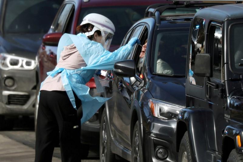 Health care worker tests people at a drive-thru testing station run by the state health department, for people who suspect they have novel coronavirus, in Denver, Colorado, on March 11, 2020. (Jim Urquhart/Reuters)