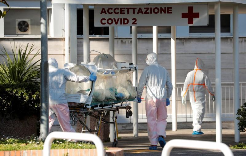 Medical workers in protective suits push an isolation stretcher in front of the Columbus Clinic, where patients suffering from COVID-19 were moved from Spallanzani Hospital, in Rome, Italy, on March 16, 2020. (Remo Casilli/File Photo/Reuters)