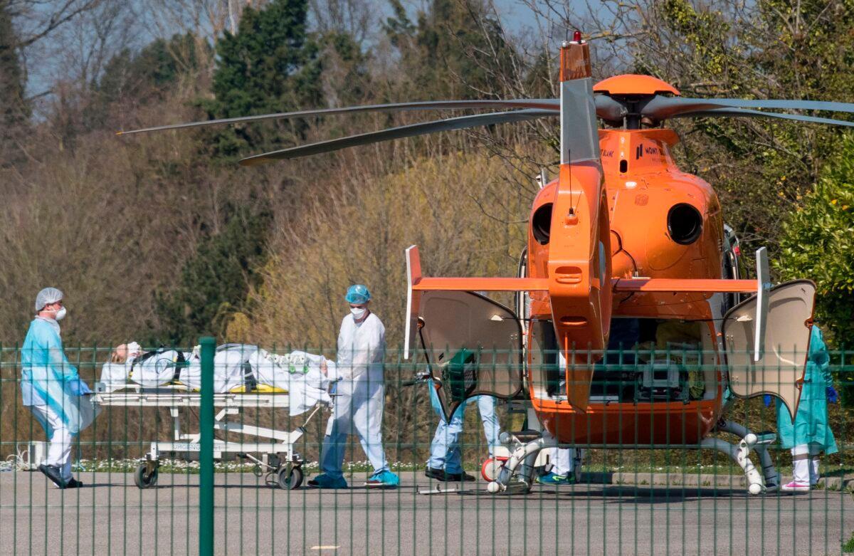 Medical staff push a patient on a gurney toward a medical helicopter at the Emile Muller hospital in Mulhouse, eastern France, to be evacuated to another hospital, on March 19, 2020. (Sebastien Bozon/AFP via Getty Images)