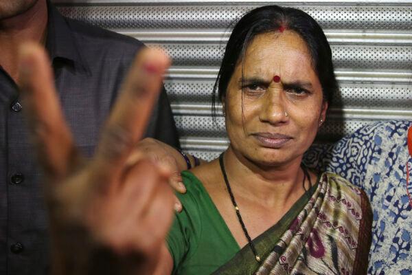 Asha Devi, mother of the victim of the fatal 2012 gang rape on a moving bus, displays a victory sign after the rapists of her daughter were hanged, in New Delhi, India, on March 20, 2020. (Altaf Qadri/AP Photo)