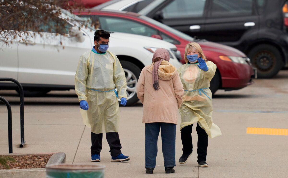 Health care workers speak with an elderly woman at a Covid-19 assessment center in London, Ontario, Canada, on March 17, 2020. (Geoff Robins/AFP via Getty Images)
