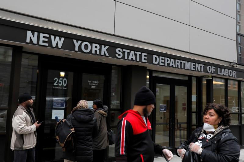 People gather at the entrance for the New York State Department of Labor offices, which closed to the public due to the COVID-19 outbreak in the Brooklyn borough of New York City on March 20, 2020. (Andrew Kelly/Reuters)