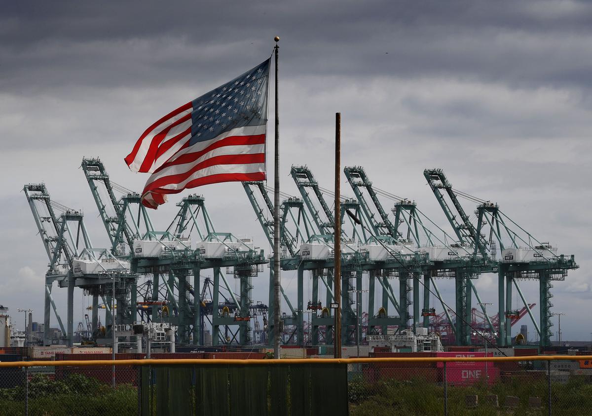 The U.S. flag flies over shipping cranes and containers after a report said the United States and China are close to reaching a major trade deal that would see both sides lower some of the tariffs imposed during an often-bitter trade war, in Long Beach, Calif., on March 4, 2019. (Mark Ralston/AFP via Getty Images)