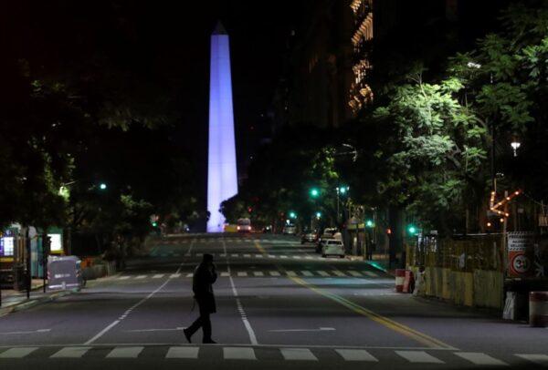 A police officer is silhouetted while walking in front of Buenos Aires' historical Obelisk after Argentina's President Alberto Fernandez announced a mandatory quarantine, in Argentina on March 20, 2020. (Reuters/Agustin Marcarian)
