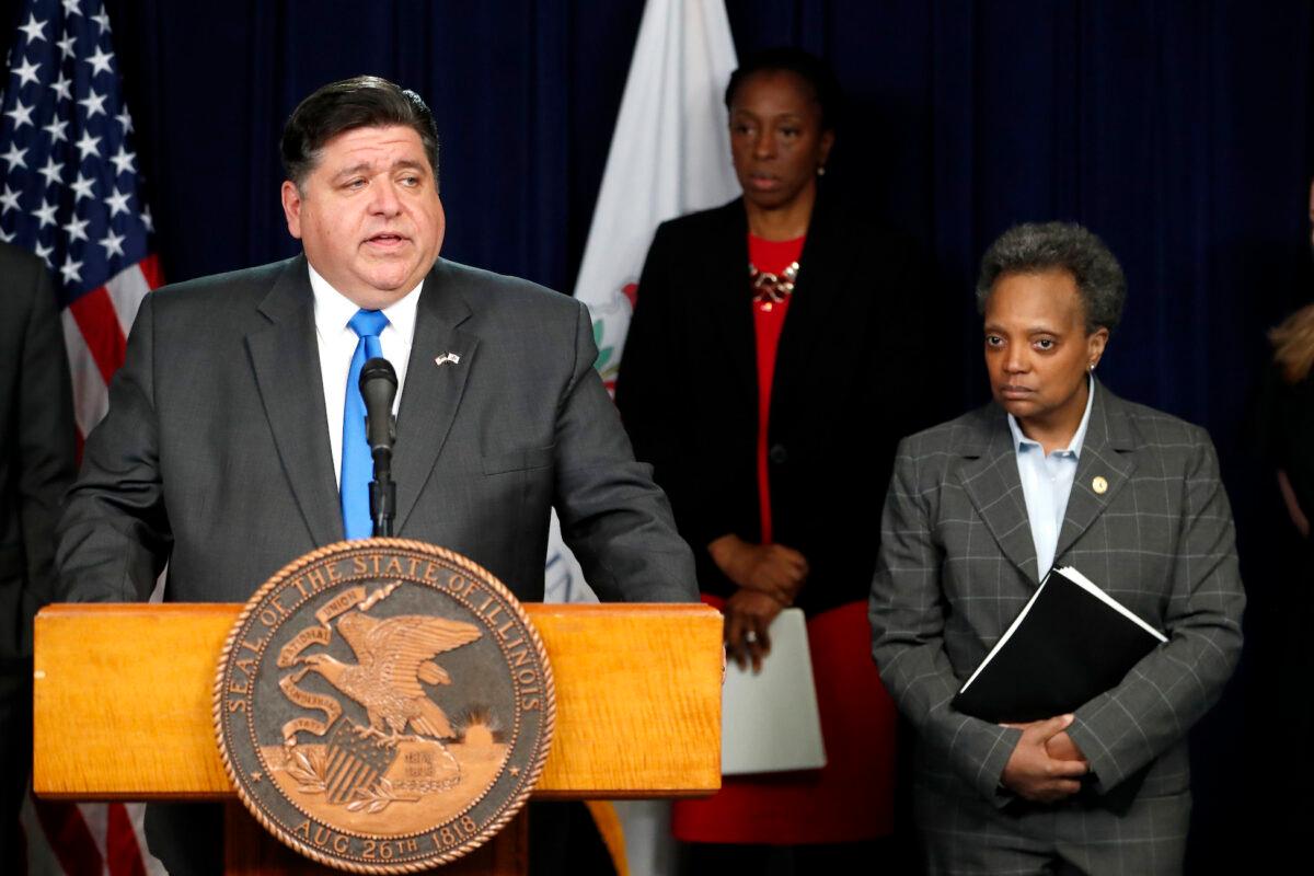 Illinois Gov. J.B. Pritzker (L), announces a shelter-in-place order to combat the spread of the COVID-19 virus, as Chicago Mayor Lori Lightfoot, right, listens, during a press conference in Chicago on March 20, 2020. (Charles Rex Arbogast/AP Photo)