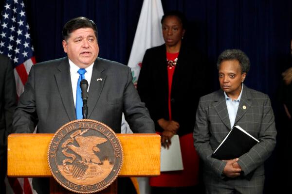 Illinois Gov. J.B. Pritzker (L) announces a shelter in place order to combat the spread of the CCP virus, as Chicago mayor Lori Lightfoot (R) listens, during a news conference in Chicago on March 20, 2020. (Charles Rex Arbogast/AP Photo)