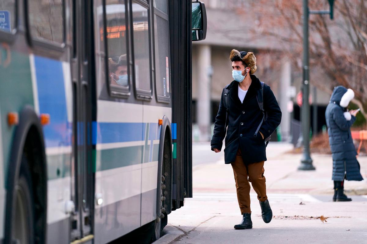 A man wearing a face mask boards a bus on campus at Western University in London, Ontario, Canada, on March 13, 2020. (Geoff Robins/AFP via Getty Images)