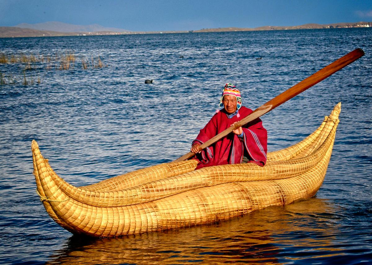 A Bolivian Andean Indian fisherman in his reed boat, which is made of held-together bundles of reeds. (Copyright Fred J. Eckert)