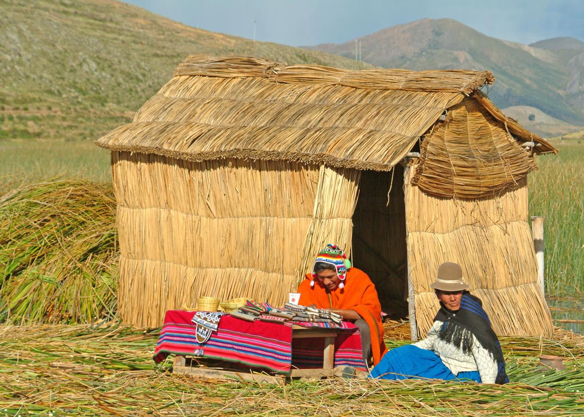 Surviving members of the Uru Iruito tribe like this man and woman live as their ancestors did on Lake Titicaca—on “floating islands” or thick floating mats made from papyrus, a reed-like aquatic plant. (Copyright Fred J. Eckert)
